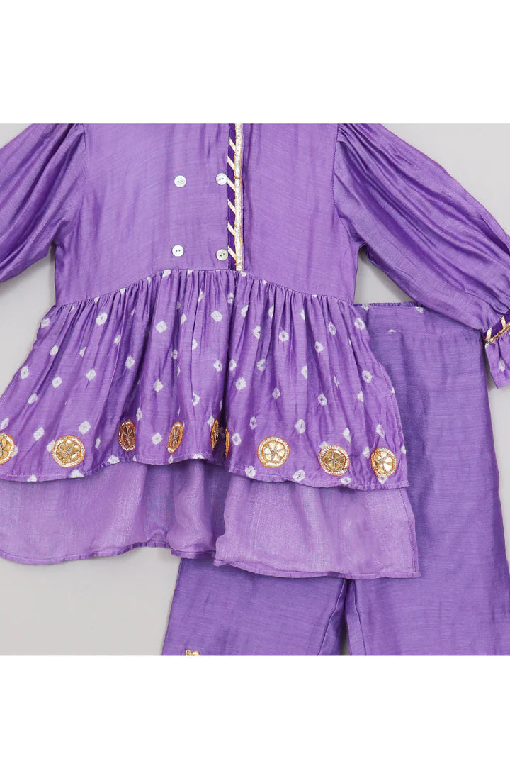 Young girl in a lilac coord set with gota lace and flowers.