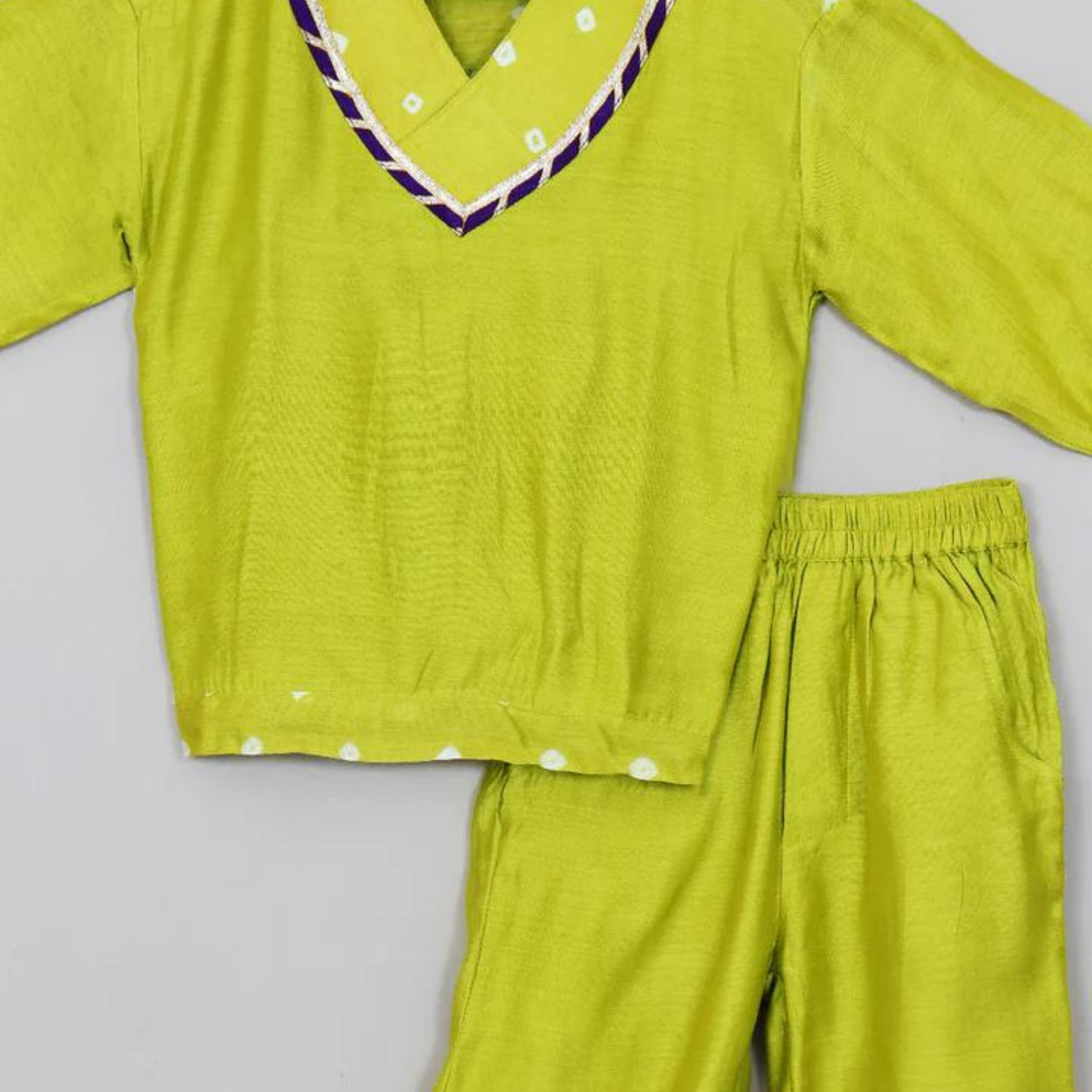 Young boy in a vibrant lime green ethnic sweatshirt and jogger set.