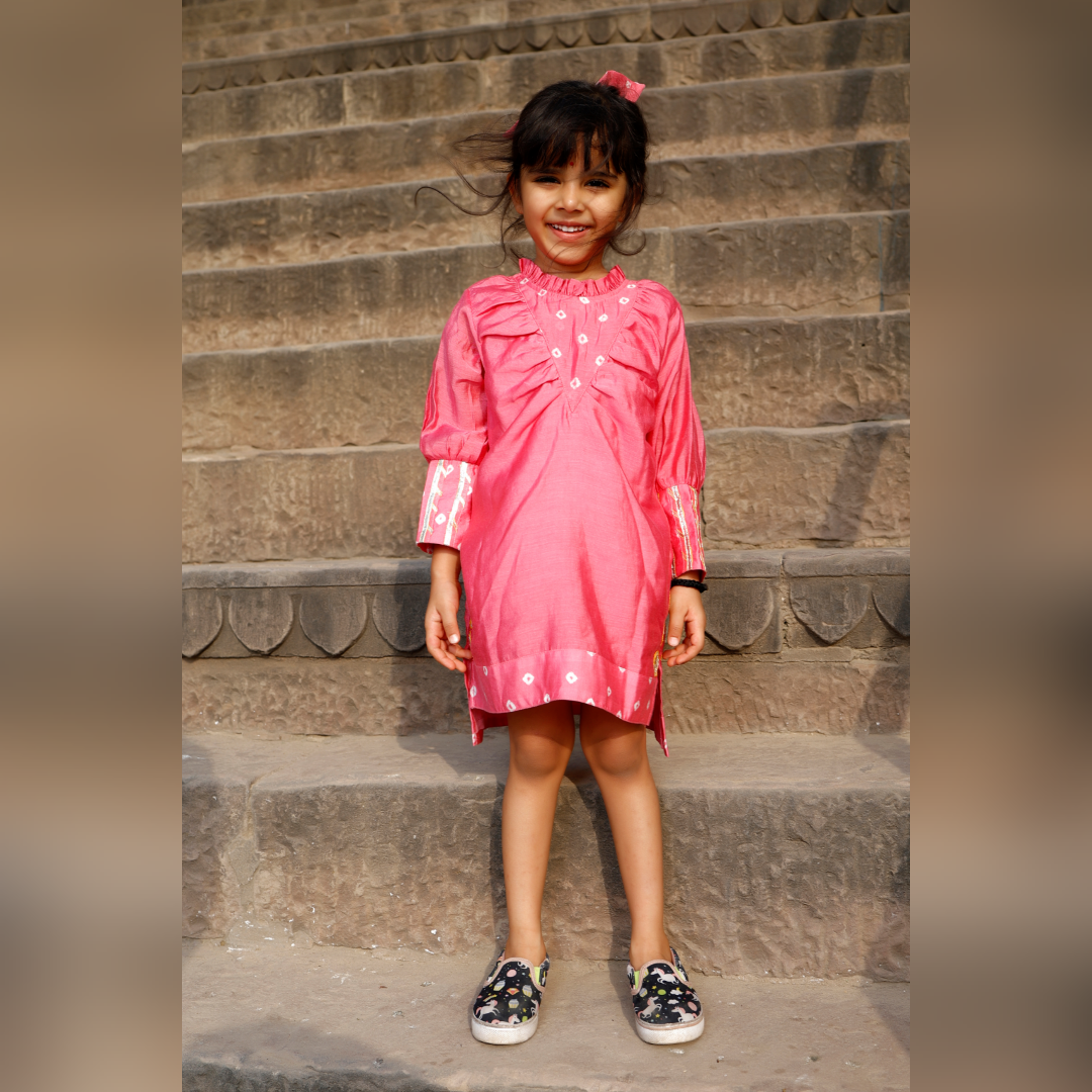 Little girl in a pink ethnic dress adorned with gota flowers and laces